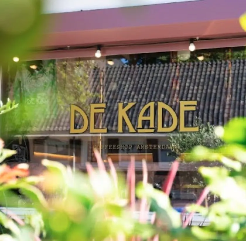 The gold De Kade sign in the coffeeshop window on Stadionkade